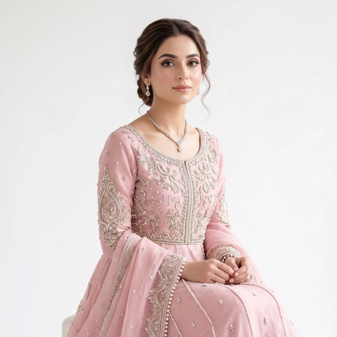 A South Asian Pakistani bride wearing an elegant embroidered pink bridal dress and jewelry, showcasing smooth, radiant skin