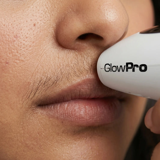 Close-up of a woman safely using the GlowPro IPL handset to target coarse, dark upper lip hair and permanently eliminate facial shadow at home.