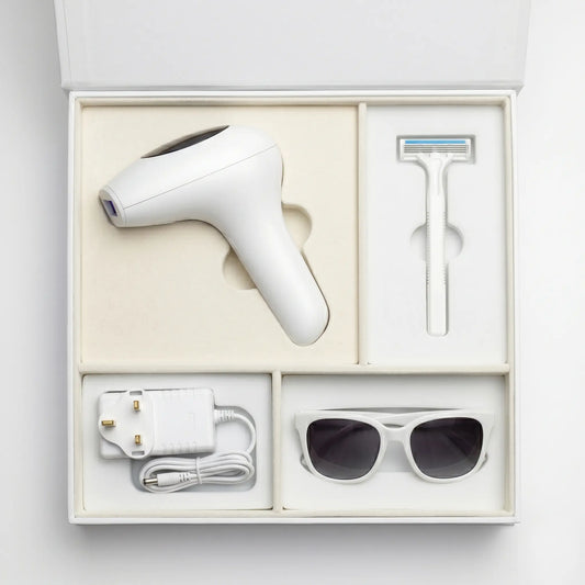 GlowPro IPL hair removal unboxing kit showing the white handset, shaving razor, power adapter, and safety glasses