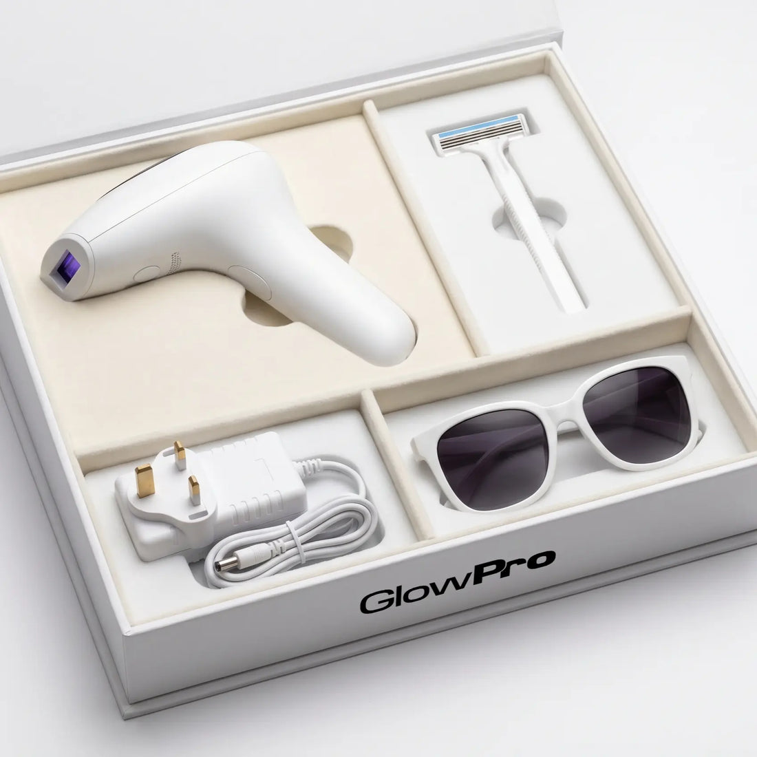 The complete GlowPro IPL+ at-home laser hair removal kit, showing the medical-grade handset, UV safety glasses, prep razor, and power supply inside a premium branded box