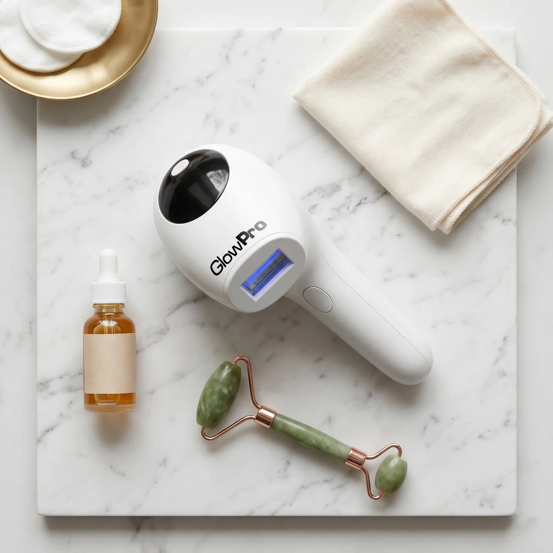 GlowPro IPL+ handset on a marble surface alongside premium, simple skincare accessories. The best and safest ipl hair removal device in pakistan.